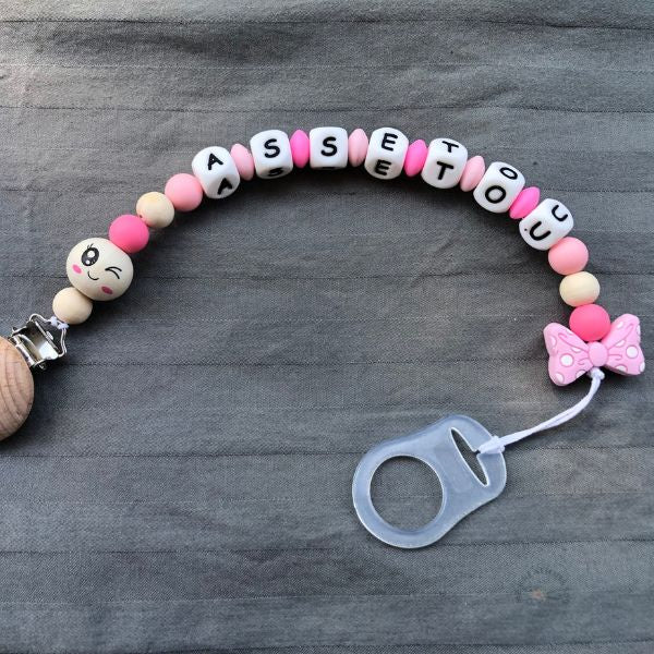 Attache tétine noeud rose